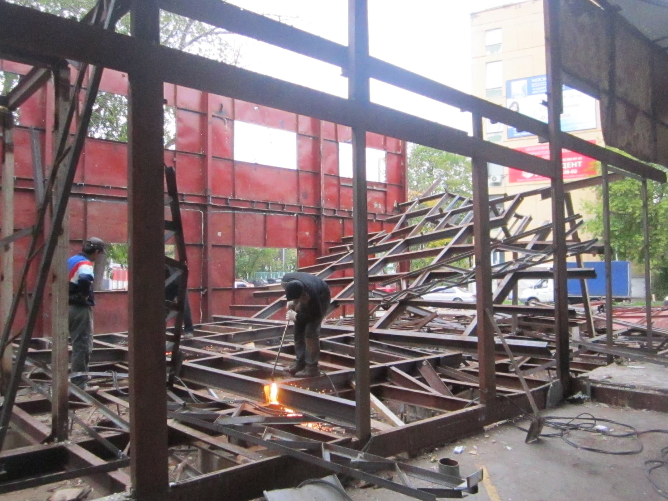 Рабочие демонтируют здание склада