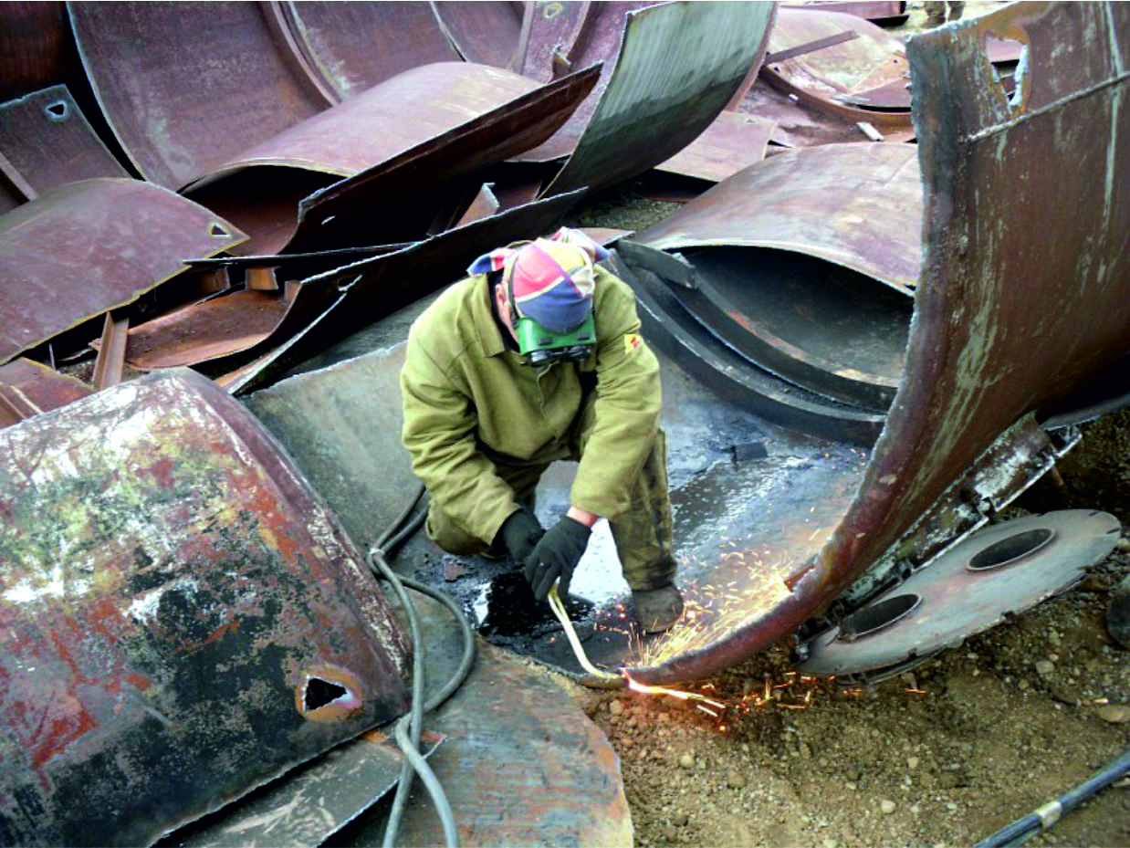 Рабочий демонтирует металлическую конструкцию